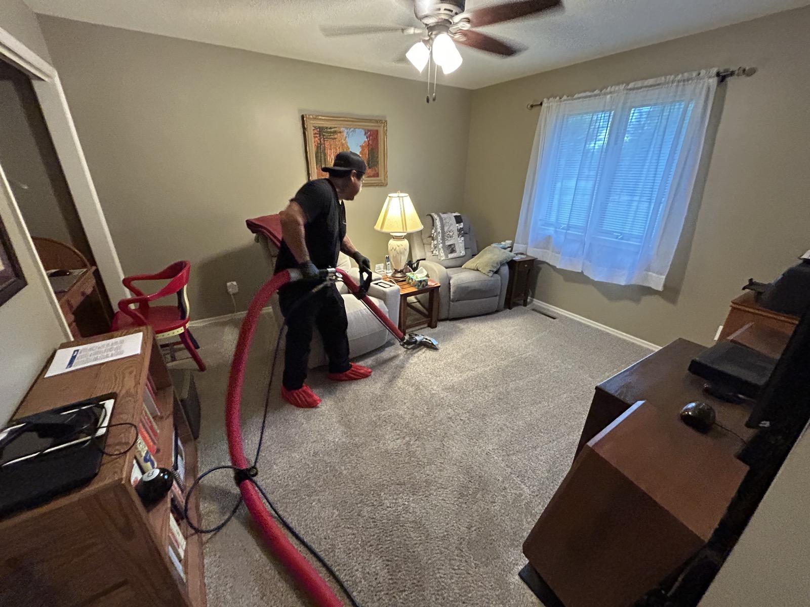 A technician steam cleaning a customer's living room carpet